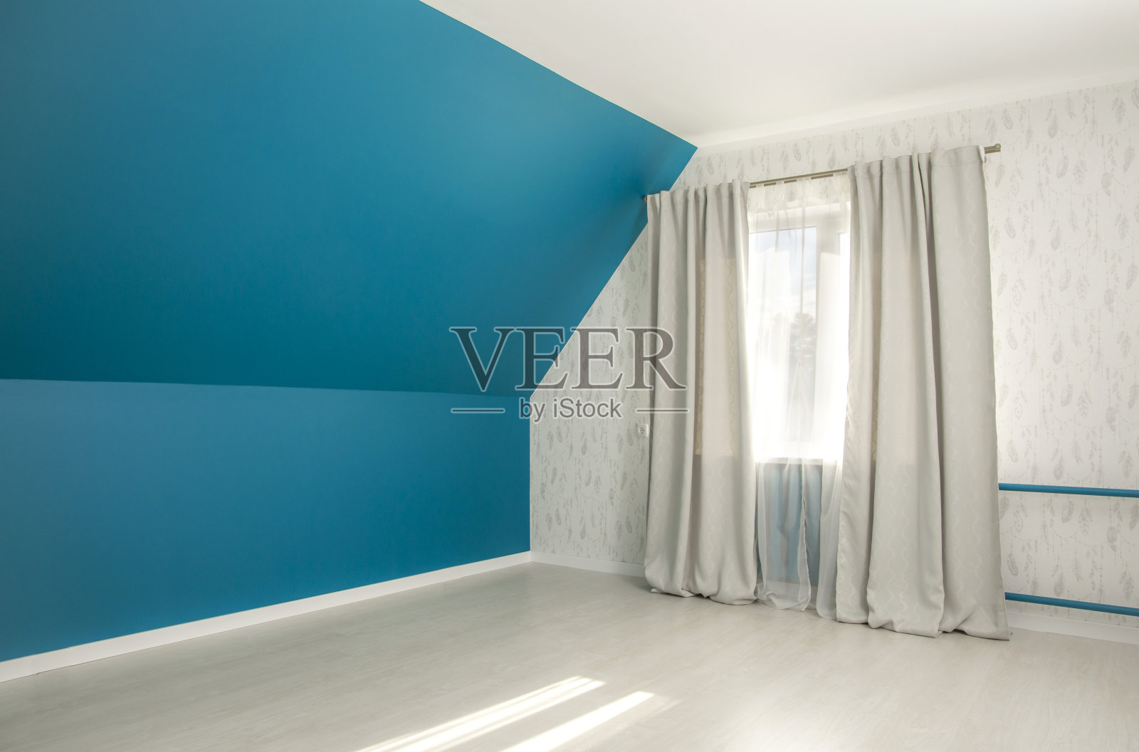 空大胆的蓝色倾斜的卧室墙，灰色窗帘，白色日光窗帘，白色拼花木地板。照片摄影图片