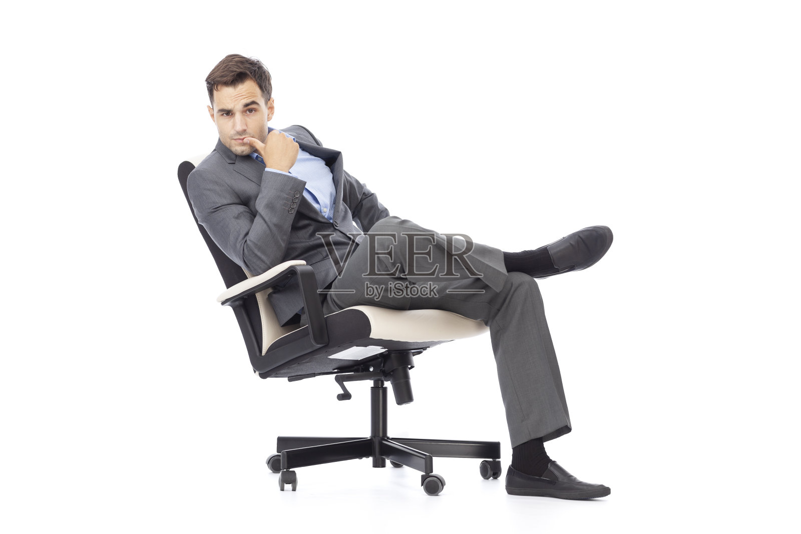 商人摆姿势，懒洋洋地坐在办公椅上。照片摄影图片