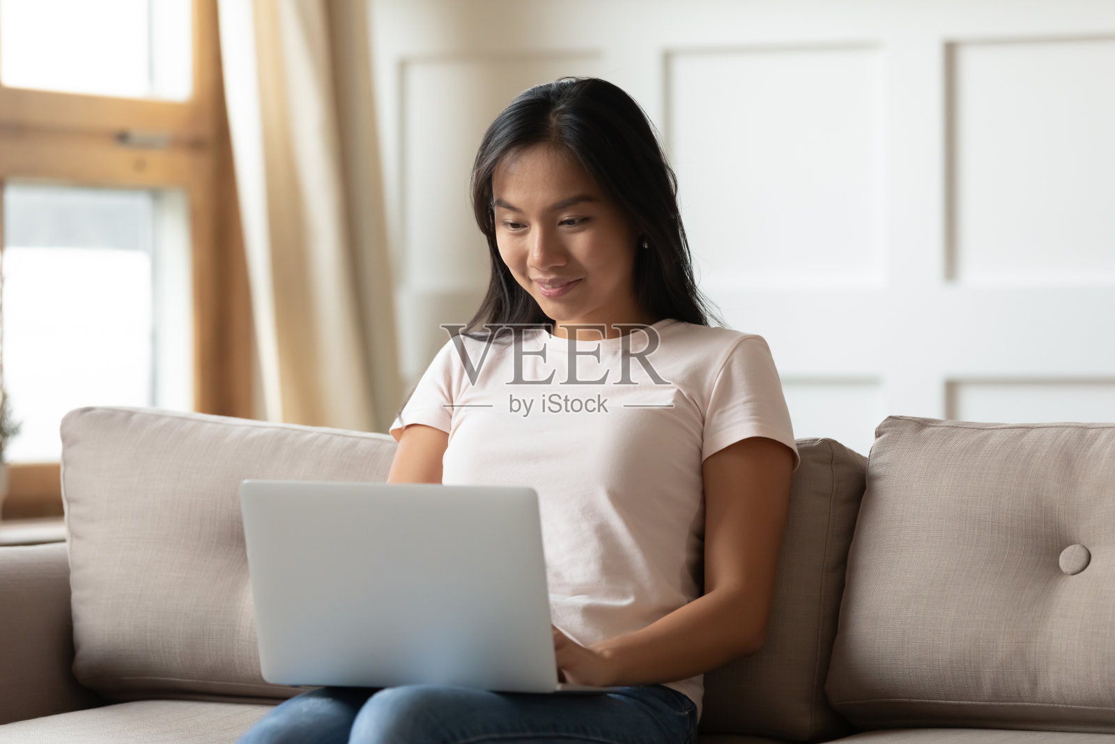 一个亚洲女人在手提电脑上打字照片摄影图片