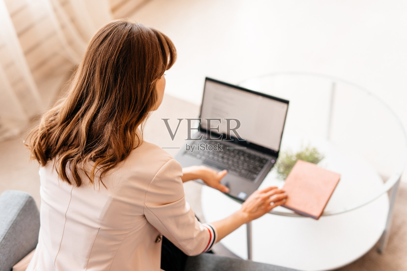 年轻迷人的女性时装设计师俯视图工作与一台笔记本电脑在家里照片摄影图片