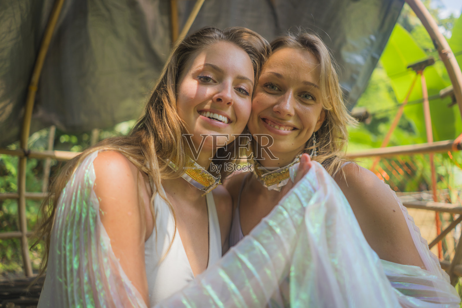 美丽和快乐的女朋友后户外瑜伽锻炼-两个年轻漂亮的女人微笑愉快享受热带丛林健身训练后的友谊和健康的生活方式的概念照片摄影图片
