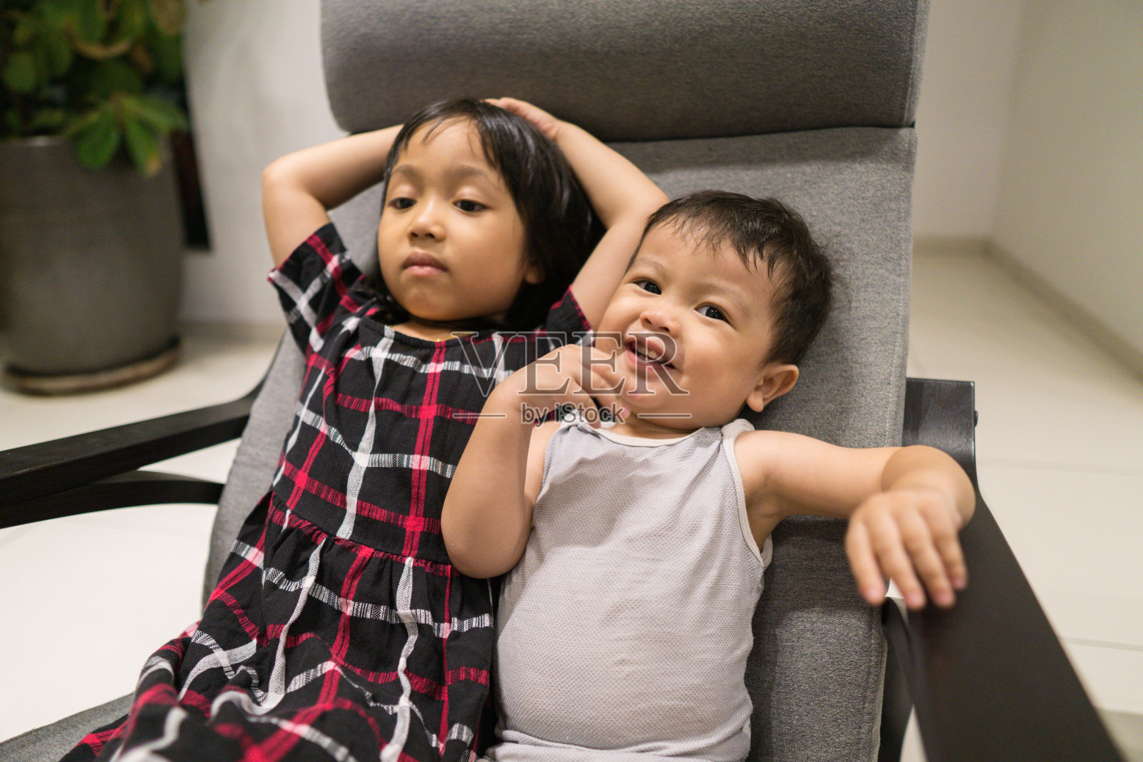 亚洲兄弟姐妹一起坐在家里的摇椅上度过美好时光照片摄影图片