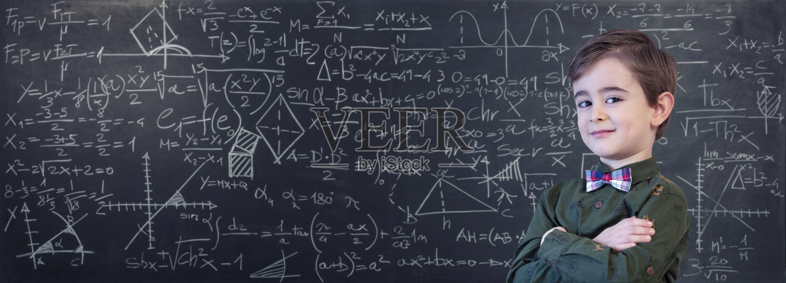 小男孩在黑板上写数学公式照片摄影图片