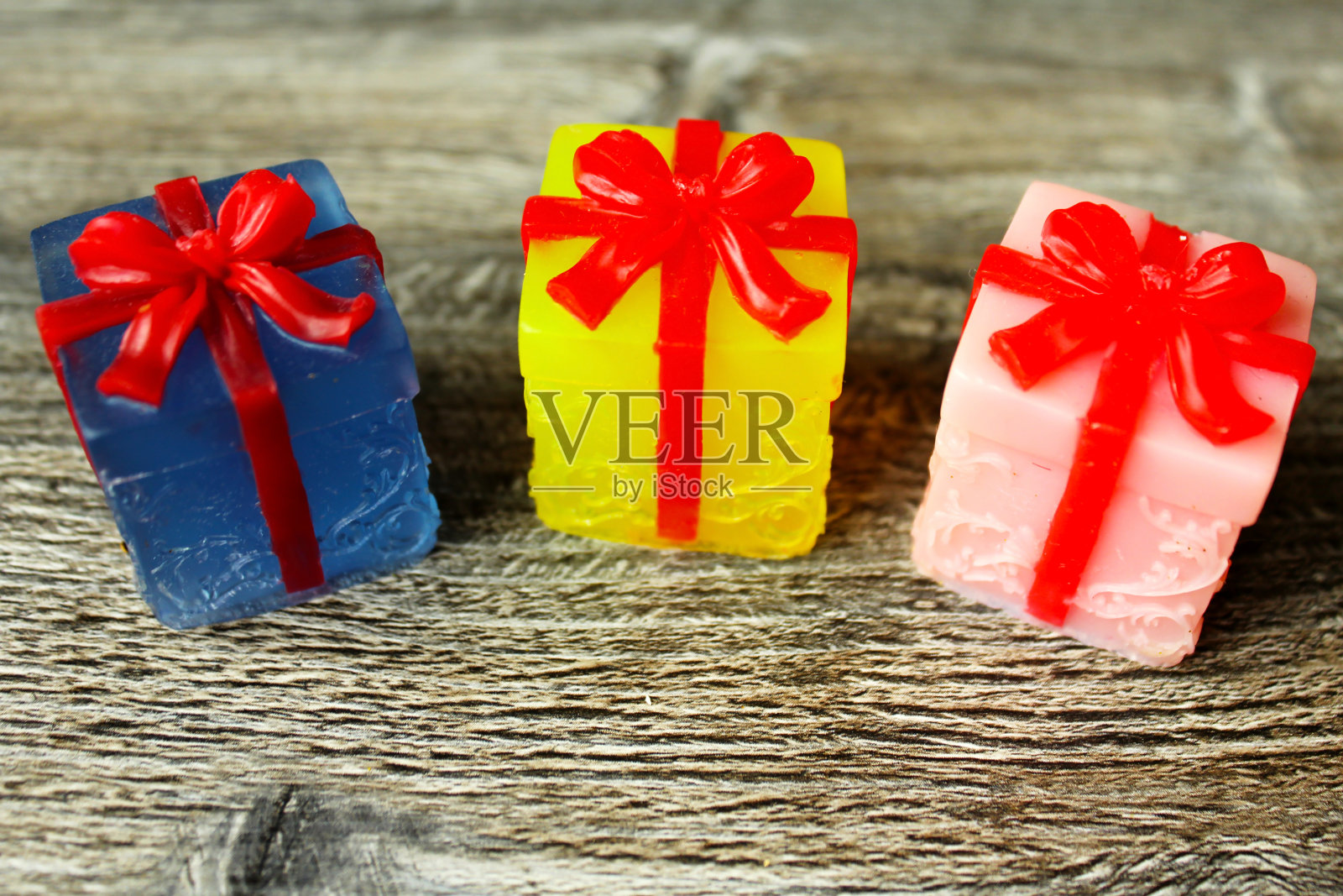 蓝色，黄色和粉红色的礼物与红色的丝带。手工肥皂。照片摄影图片