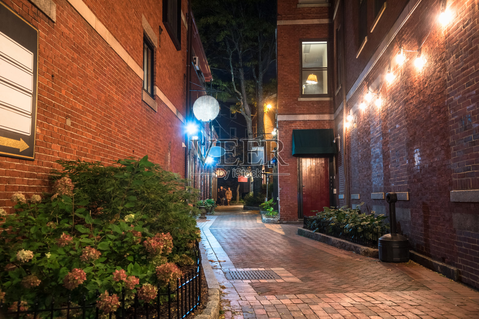 夜晚，市中心狭窄的步行街，两旁是古老的砖砌建筑照片摄影图片