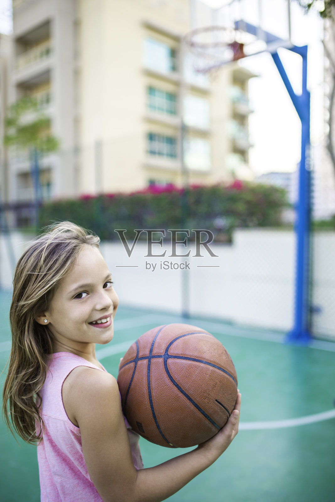 可爱的女孩在迪拜的公园里打篮球的特写照片照片摄影图片