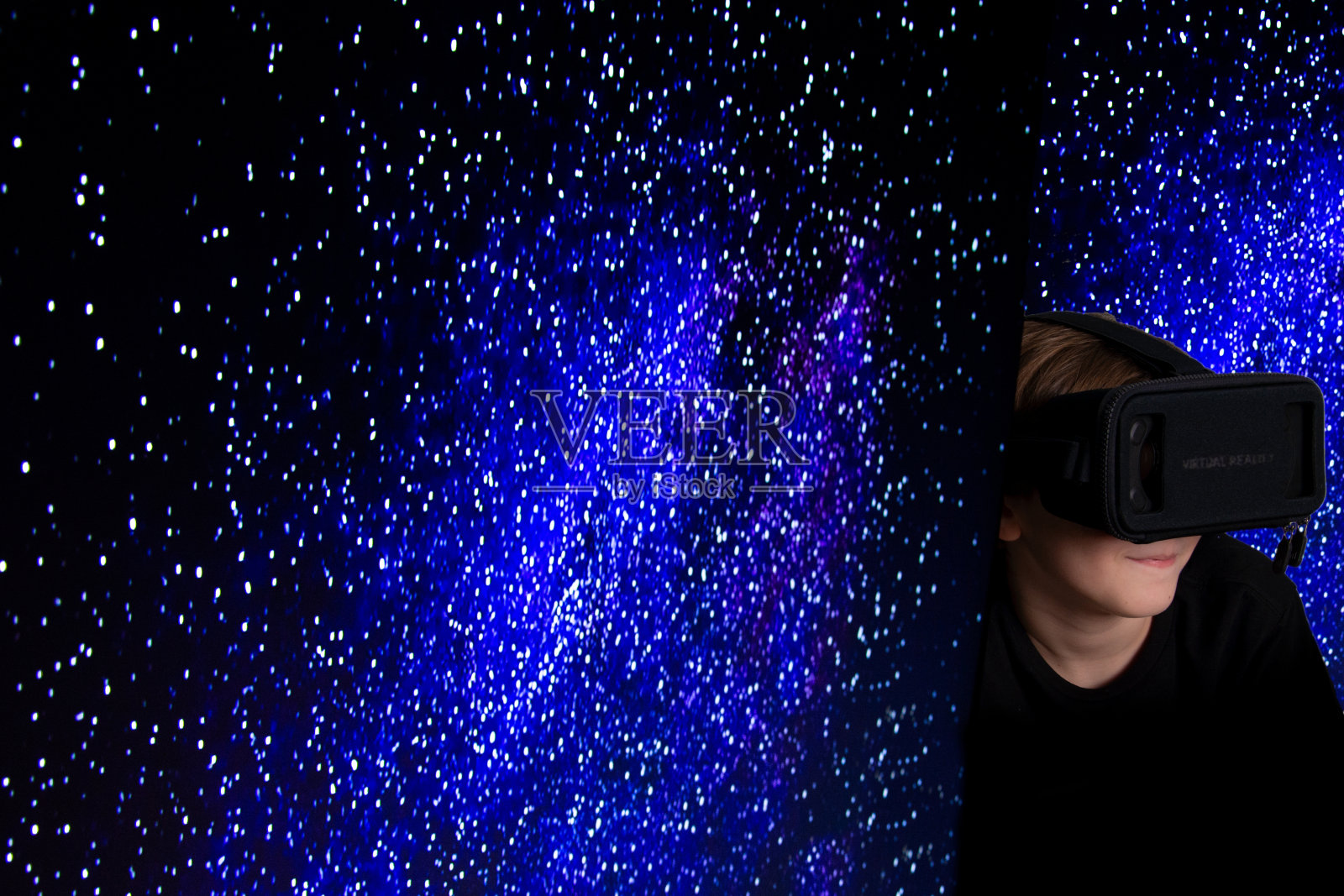 带着3d虚拟现实眼镜和银河背景的男孩照片摄影图片