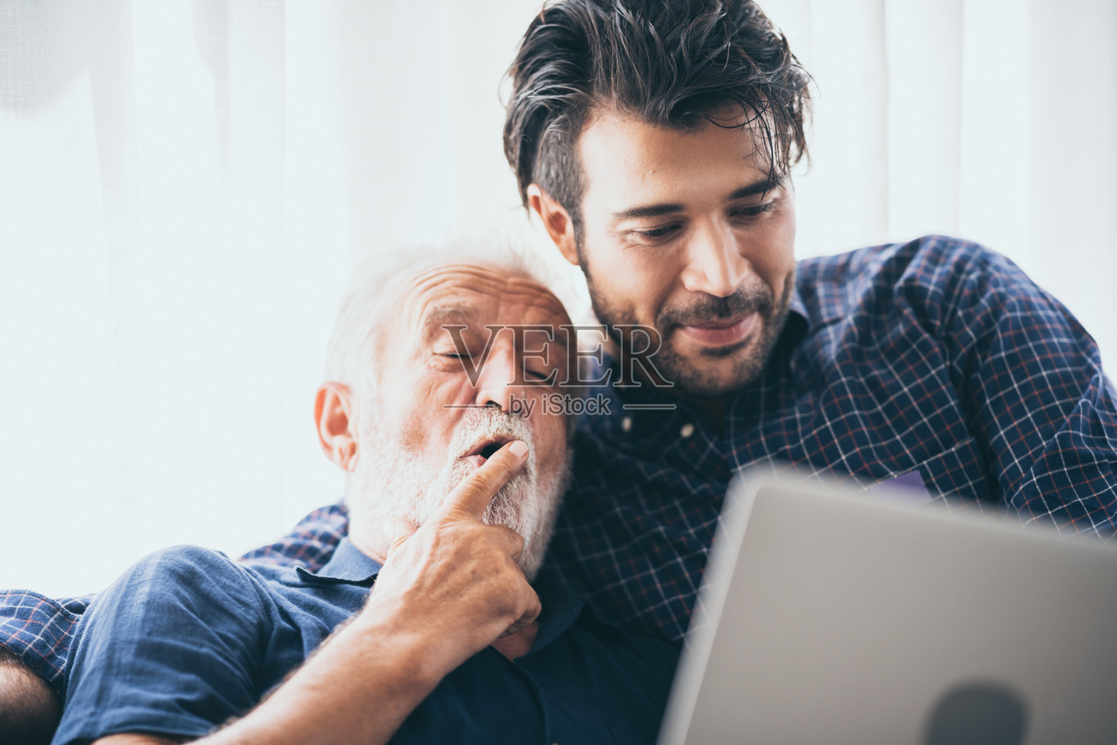 一个成年潮人的儿子和一个年长的父亲在家里聊天。照片摄影图片