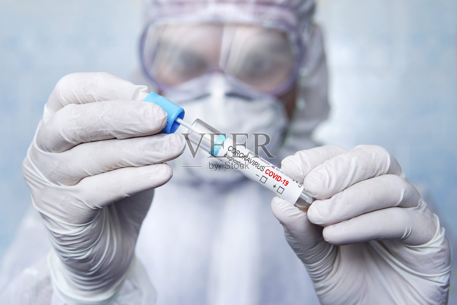 冠状病毒Covid-19呼吸道痰标本拭子试管用手套、口罩。身着防护服的专家正在检查SARS-CoV-2病毒样本。疑似COVID-19患者痰液检查照片摄影图片