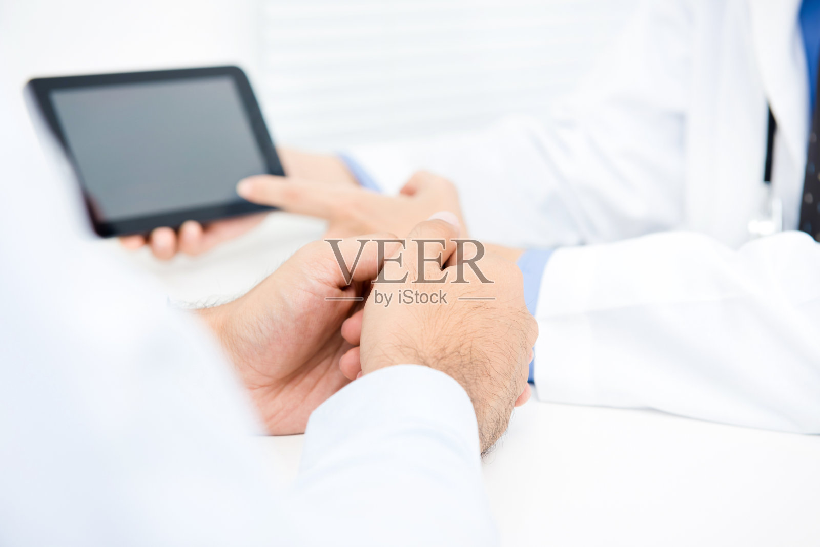 医生用平板电脑向男性患者讲解治疗方法照片摄影图片