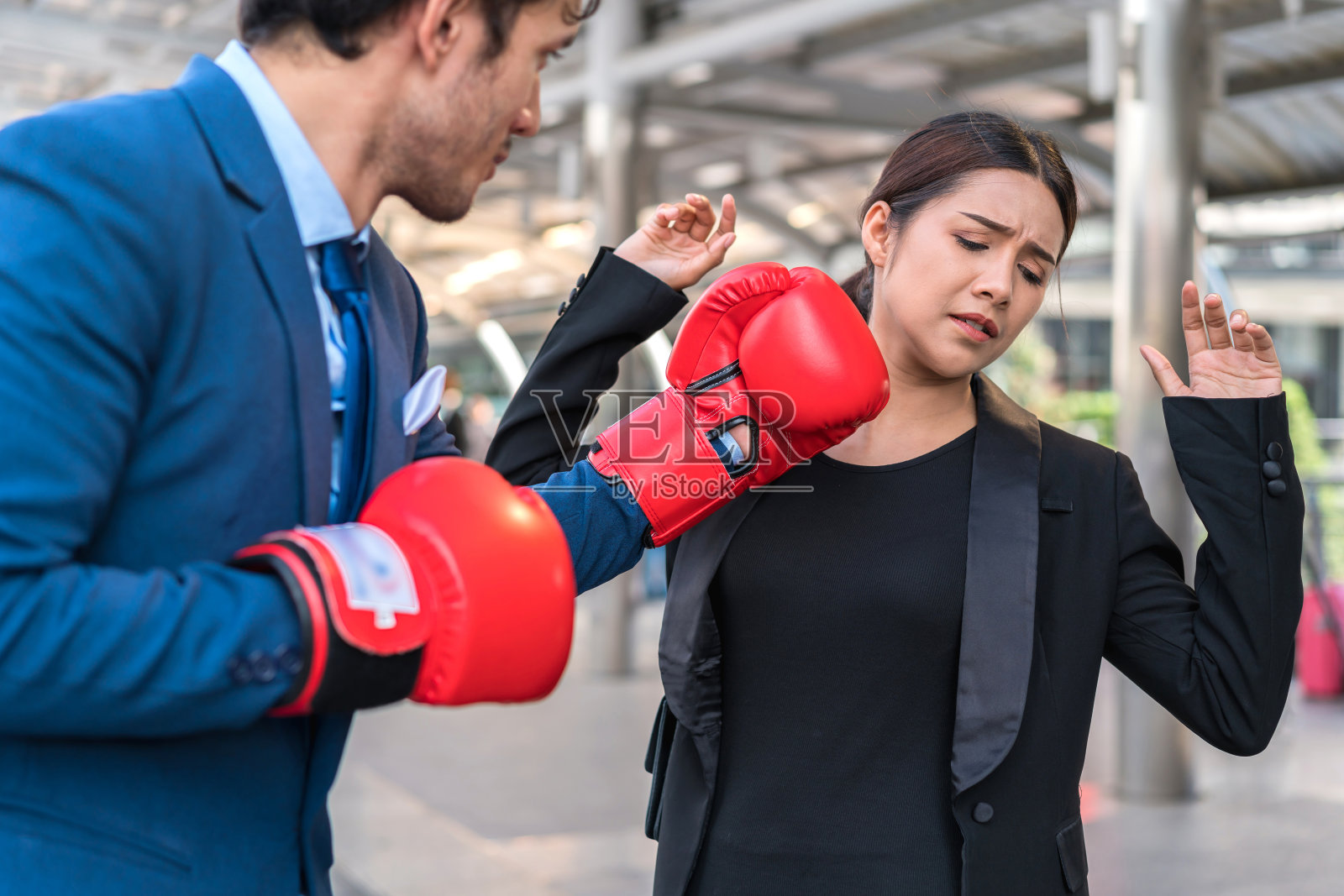 商人们戴着红手套打架。男人给女人一拳。商业竞争的概念。照片摄影图片