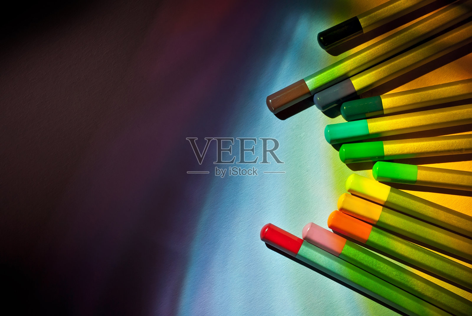 彩色铅笔在纸上的背景接近。大量的铅笔与反差的戏剧性的光线。文本的自由拷贝空间。模型。照片摄影图片