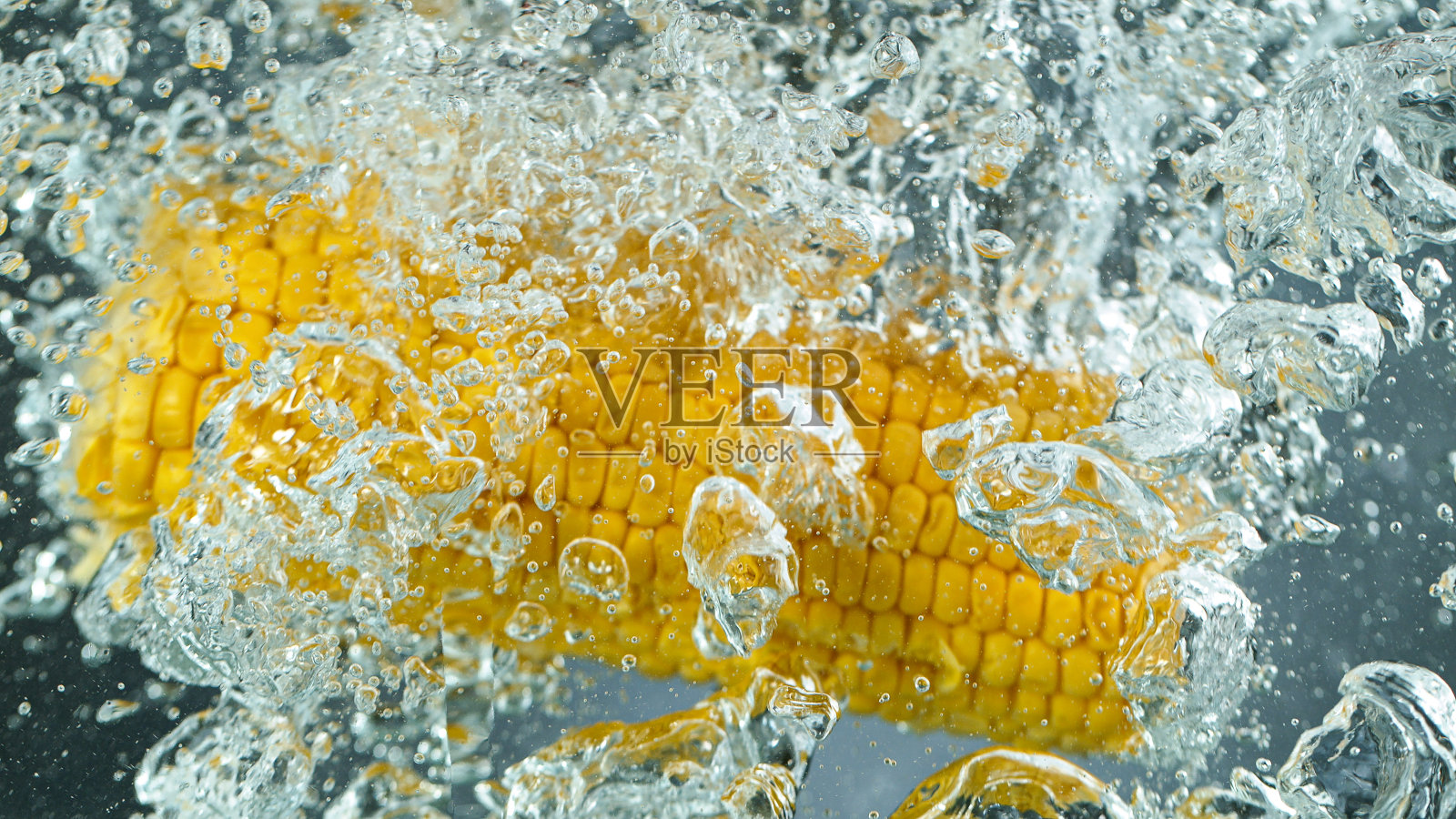 把玉米扔进开水里，冷冻运动。照片摄影图片