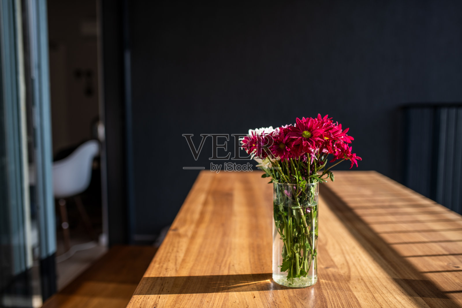 木桌上放着漂亮的花。照片摄影图片