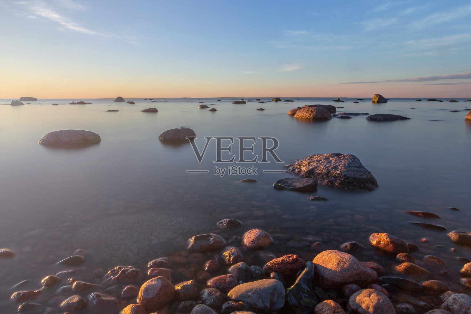 波罗的海海岸的石头和美丽的日落，长曝光照片作为背景明信片照片摄影图片