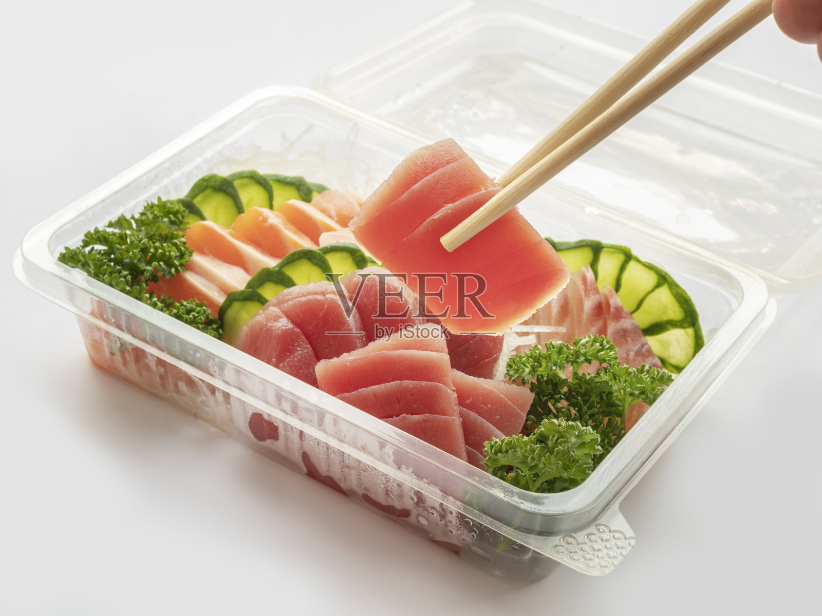 套寿司装在塑料盒里，送回家准备吃的健康快餐，隔离上白照片摄影图片