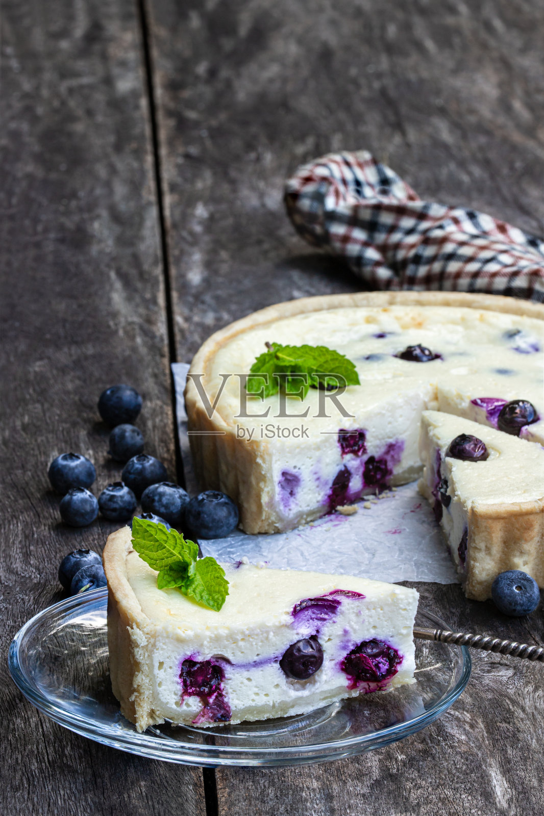 乡村木桌上放着蓝莓芝士蛋糕。夏天的甜点照片摄影图片