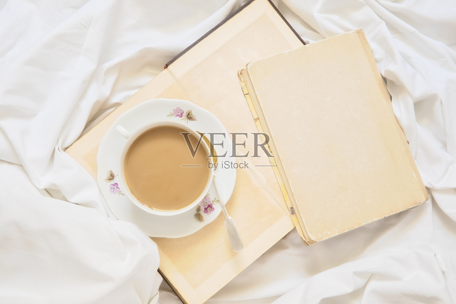 一杯卡布奇诺站在一本书和一张白纸上照片摄影图片