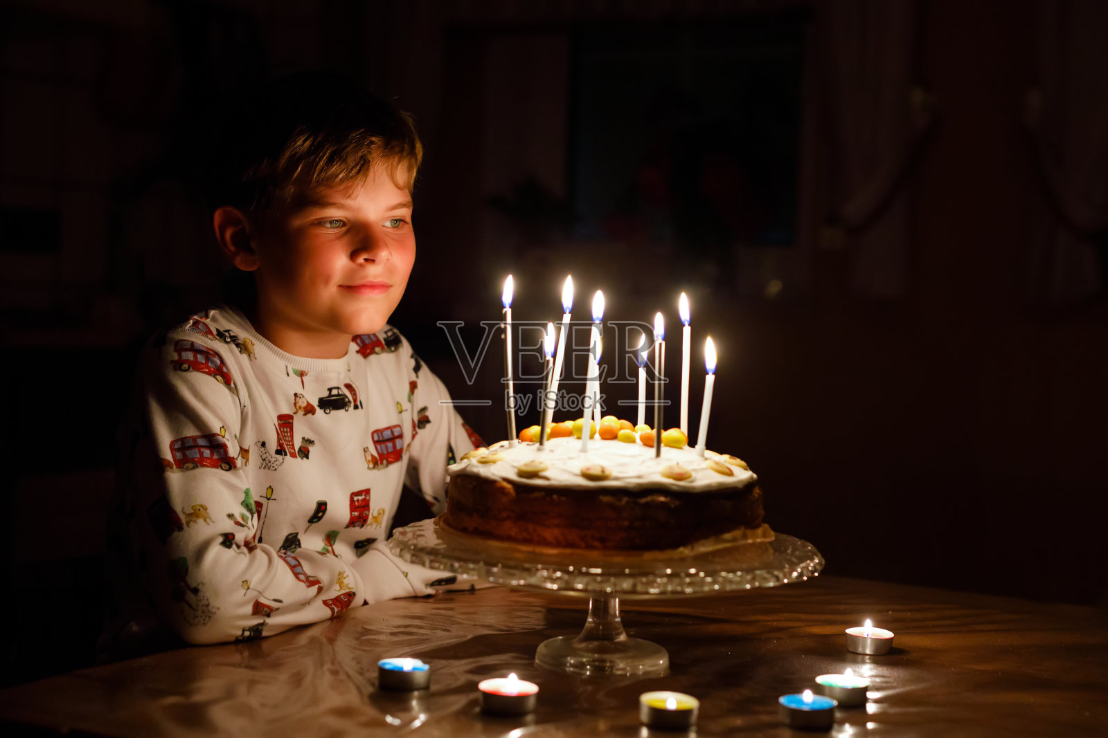 可爱的快乐的金发小男孩庆祝他的生日。孩子吹蜡烛在自制的烤蛋糕，室内。孩子们的生日聚会，家庭庆典照片摄影图片