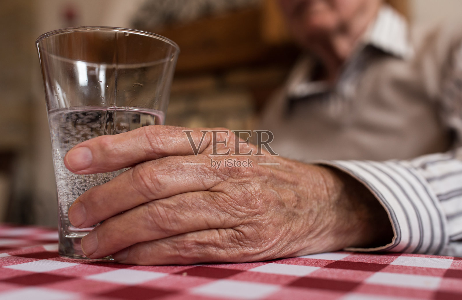 老人拿着一杯水照片摄影图片