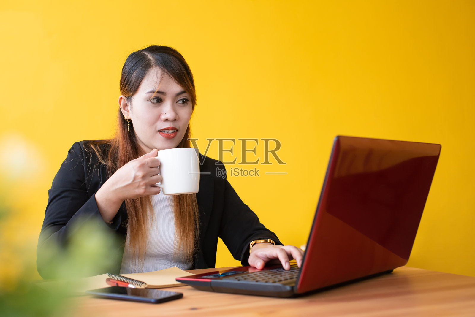 年轻的女商人在办公室休息一下，喝杯热咖啡照片摄影图片