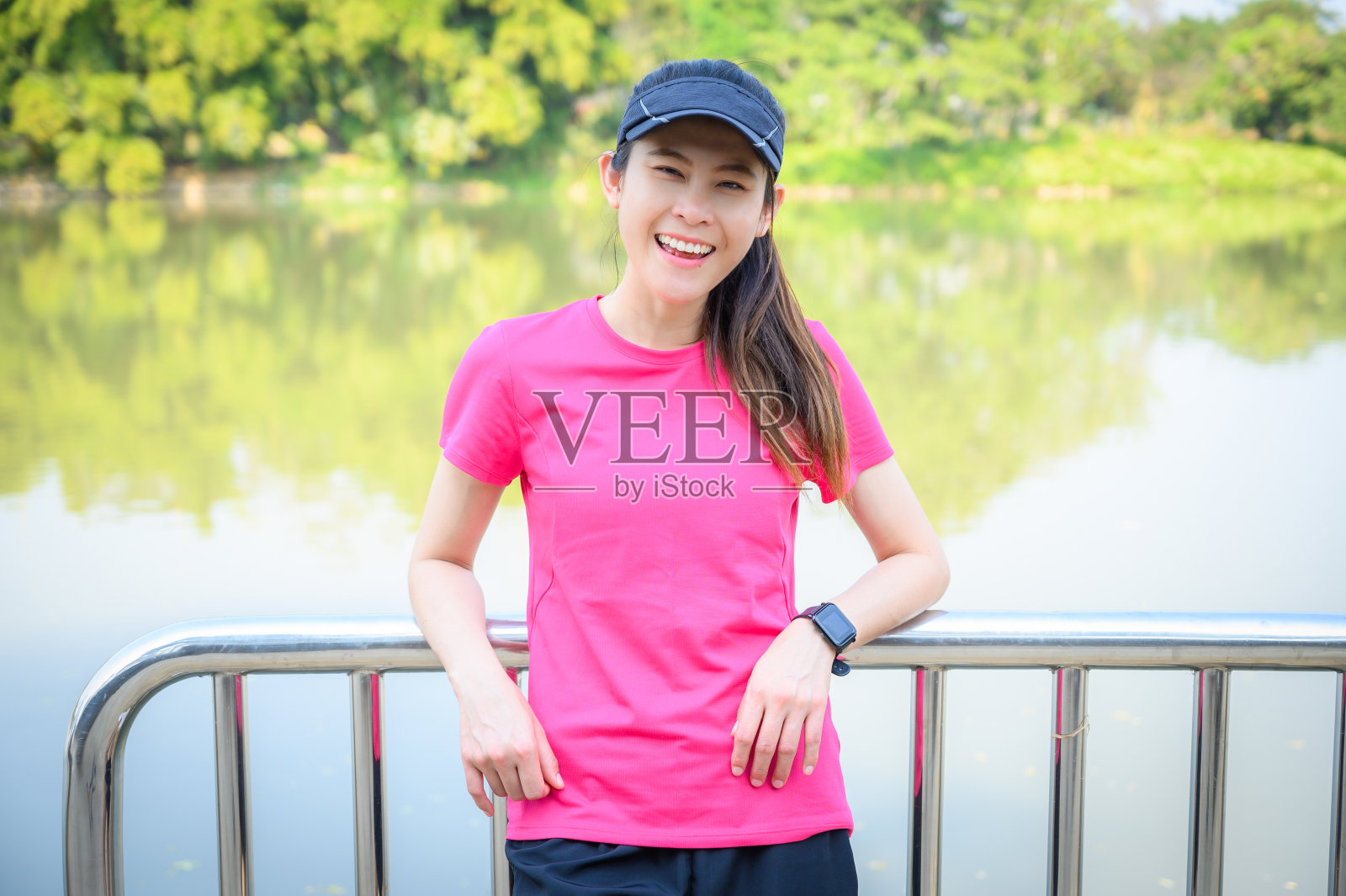 幸福女人的肖像穿着运动服，站在河边，准备锻炼。照片摄影图片