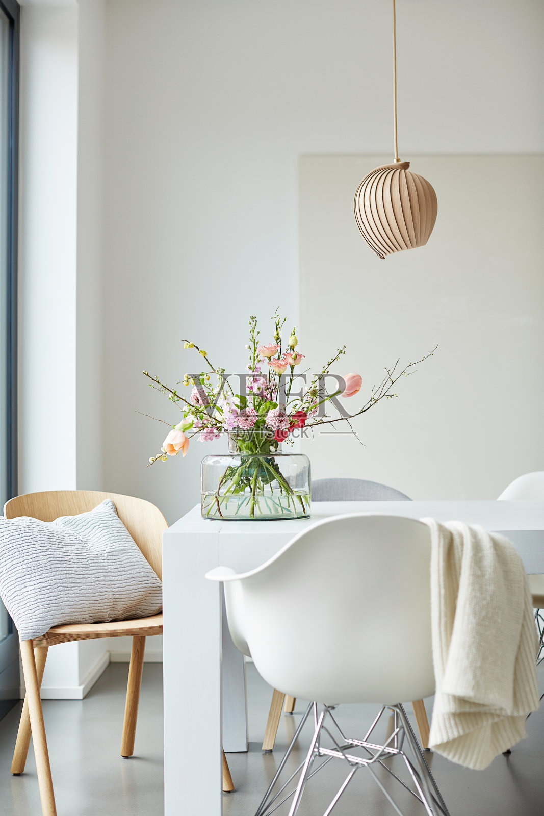 不同的照片装饰的白色餐桌在一个明亮的环境与鲜花和花瓶照片摄影图片