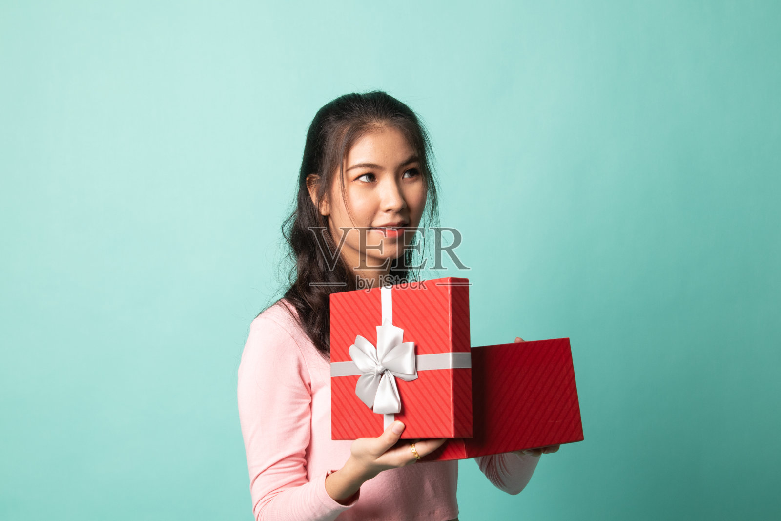 年轻的亚洲女子打开礼品盒。照片摄影图片