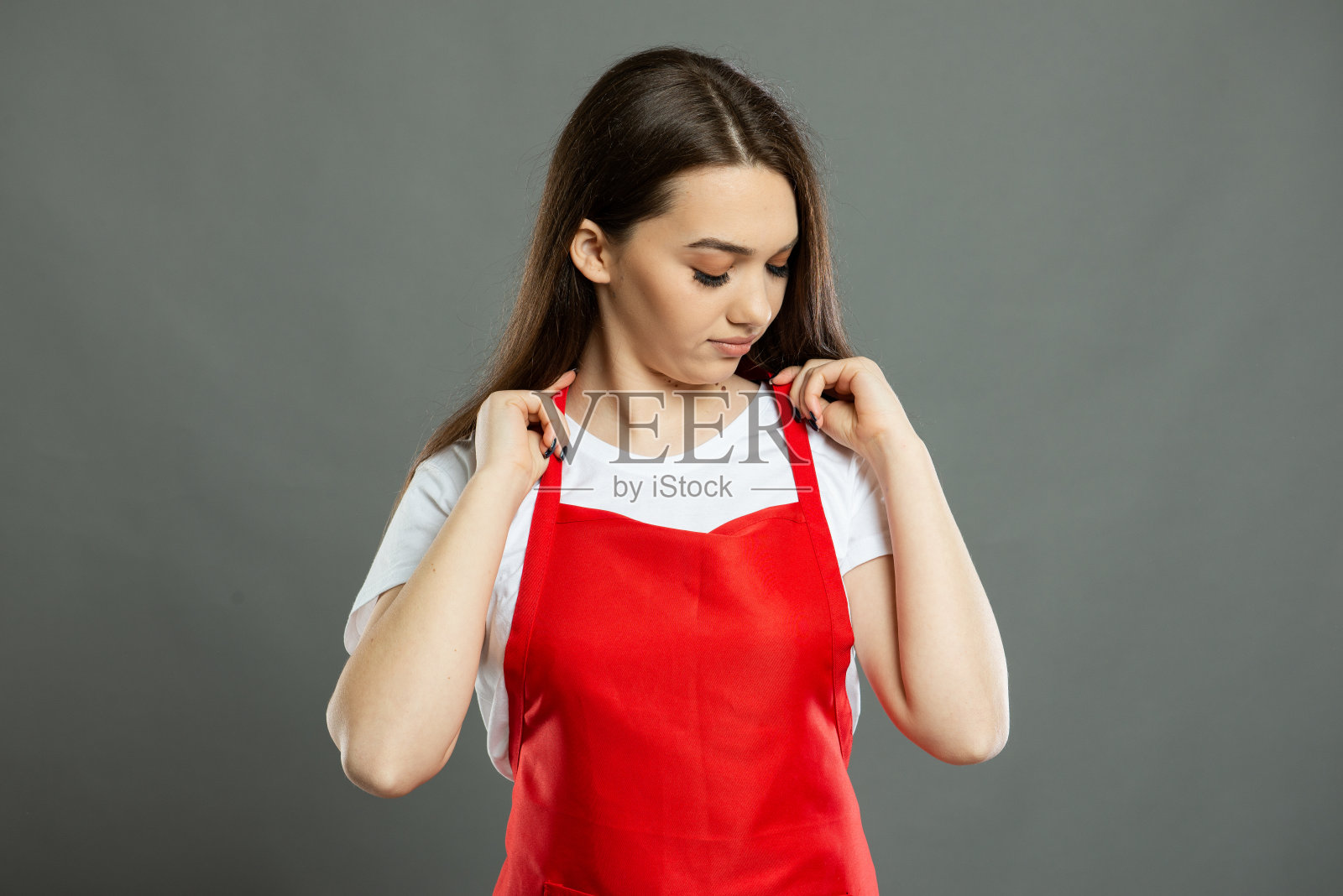 年轻女超市员工整理围裙的肖像照片摄影图片
