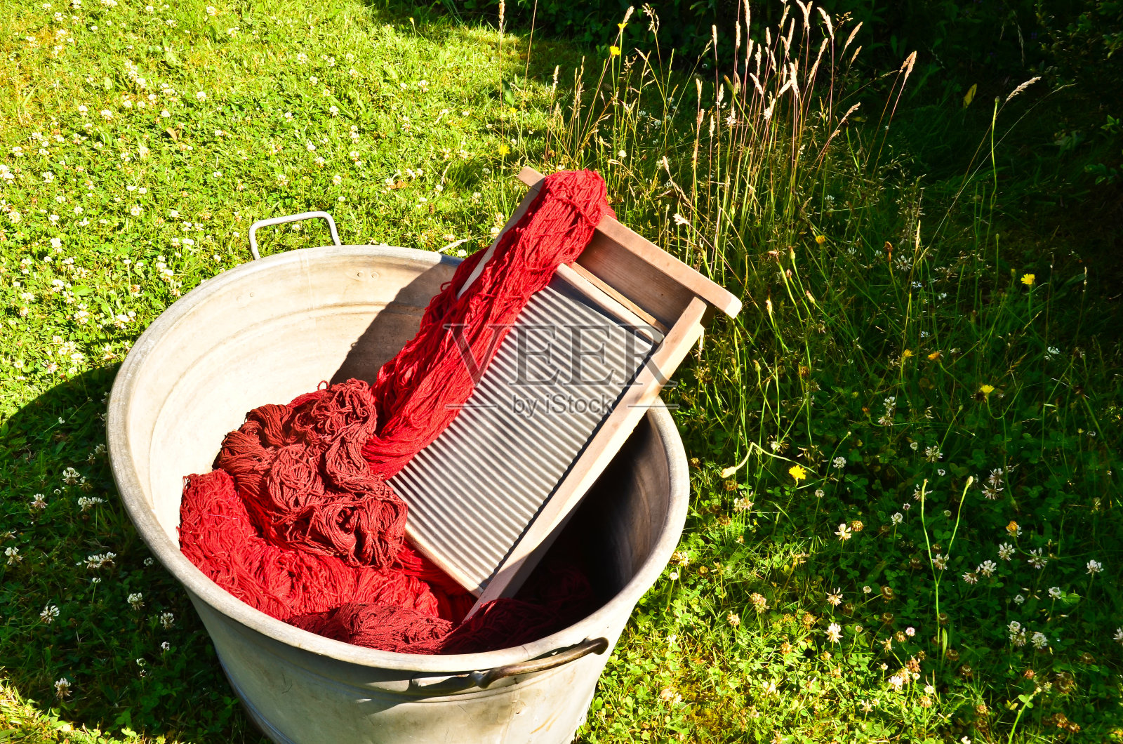 一种老式的洗涤槽，里面装满染过和洗过的红色羊毛绳照片摄影图片