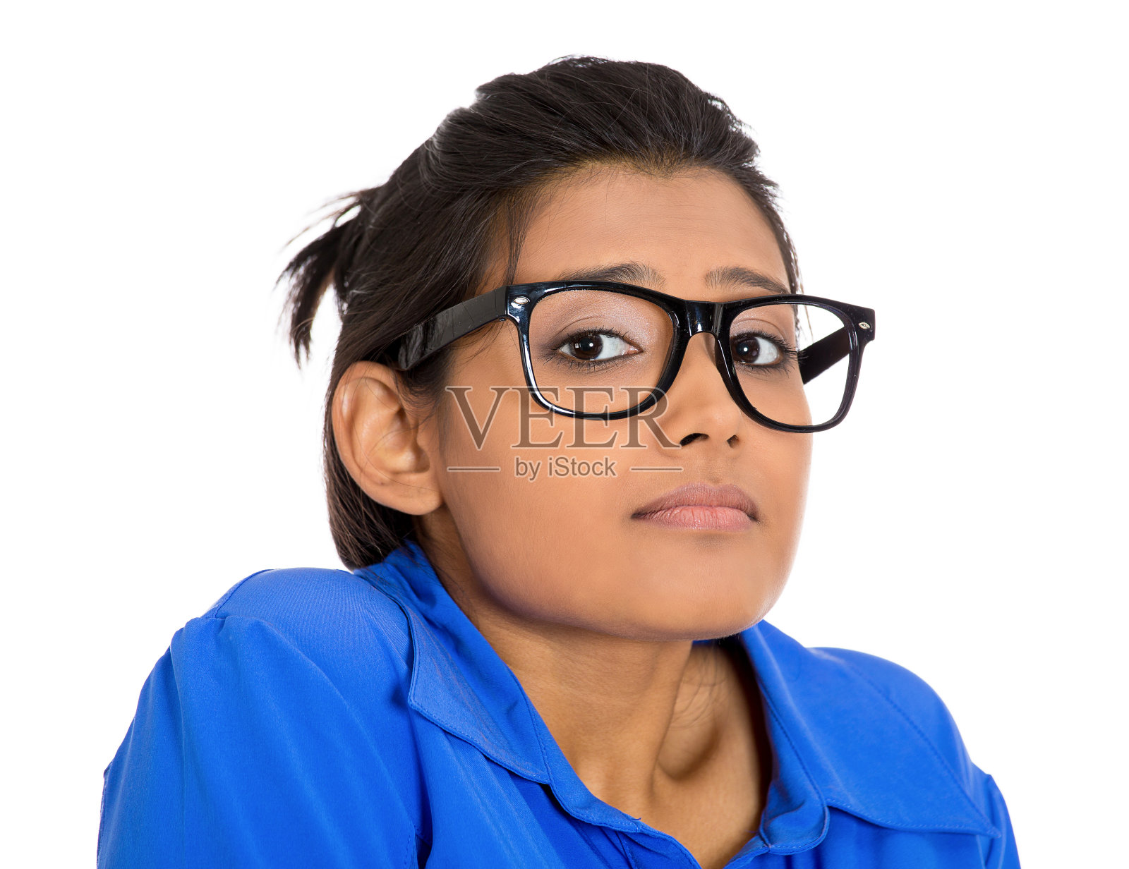一个年轻的书呆子女人的肖像戴着大眼镜，非常胆小害羞和焦虑地看着你照片摄影图片