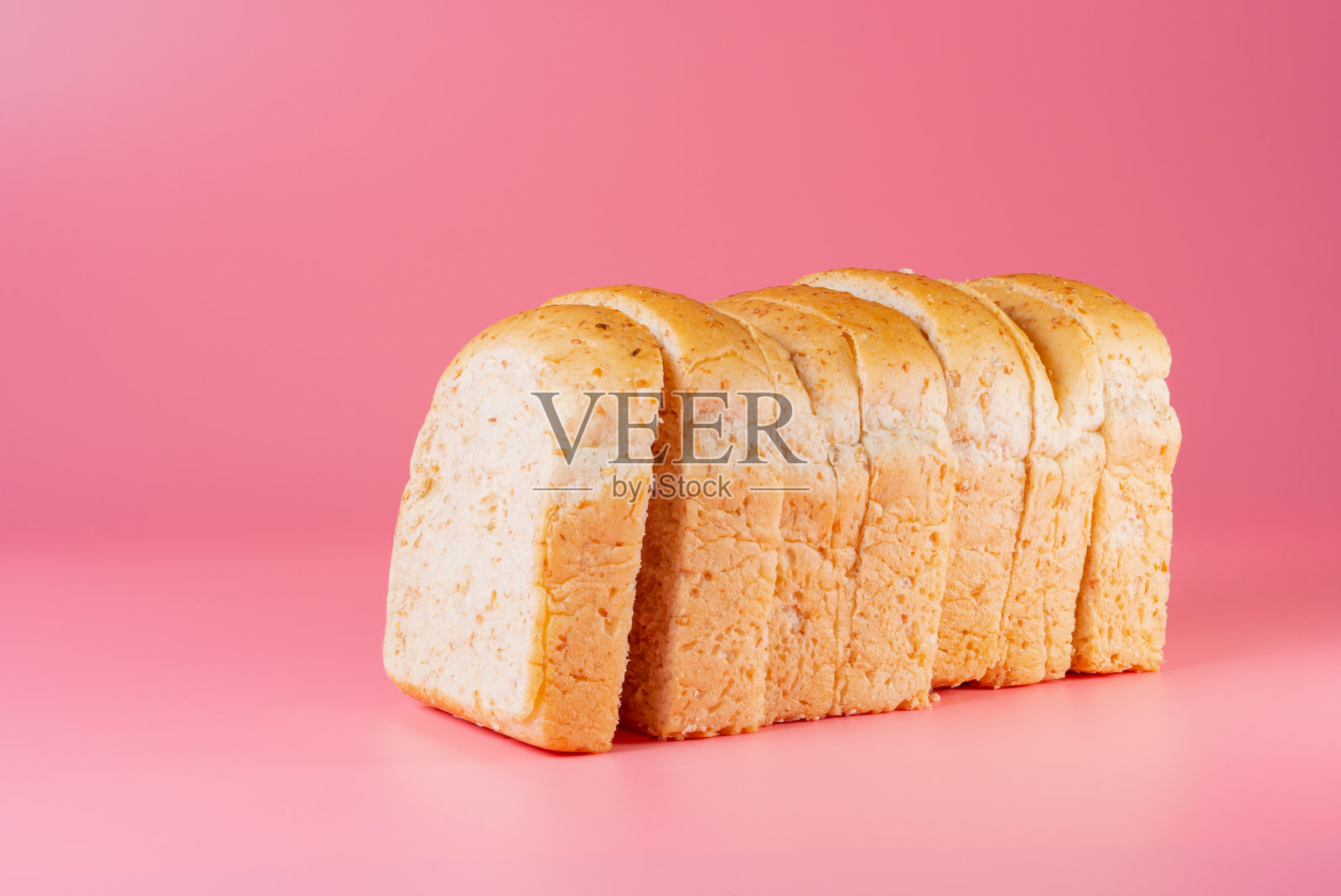 切片全麦面包孤立在粉红色的背景照片摄影图片