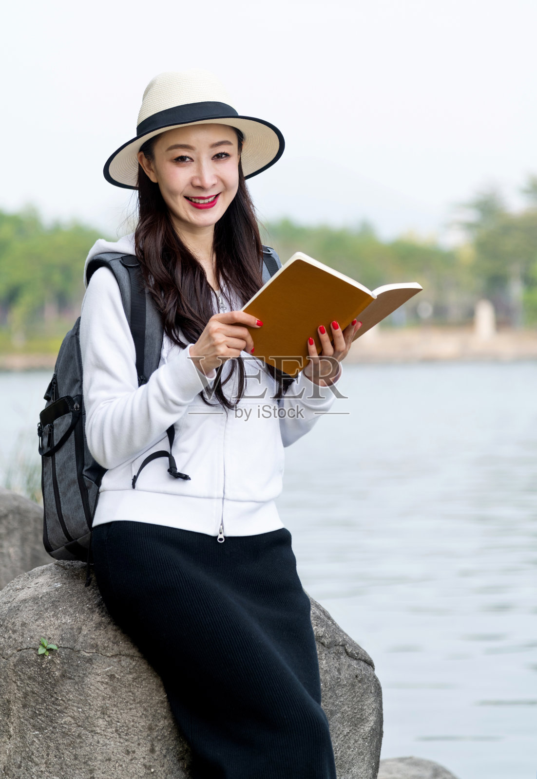 年轻女子在湖边读书照片摄影图片