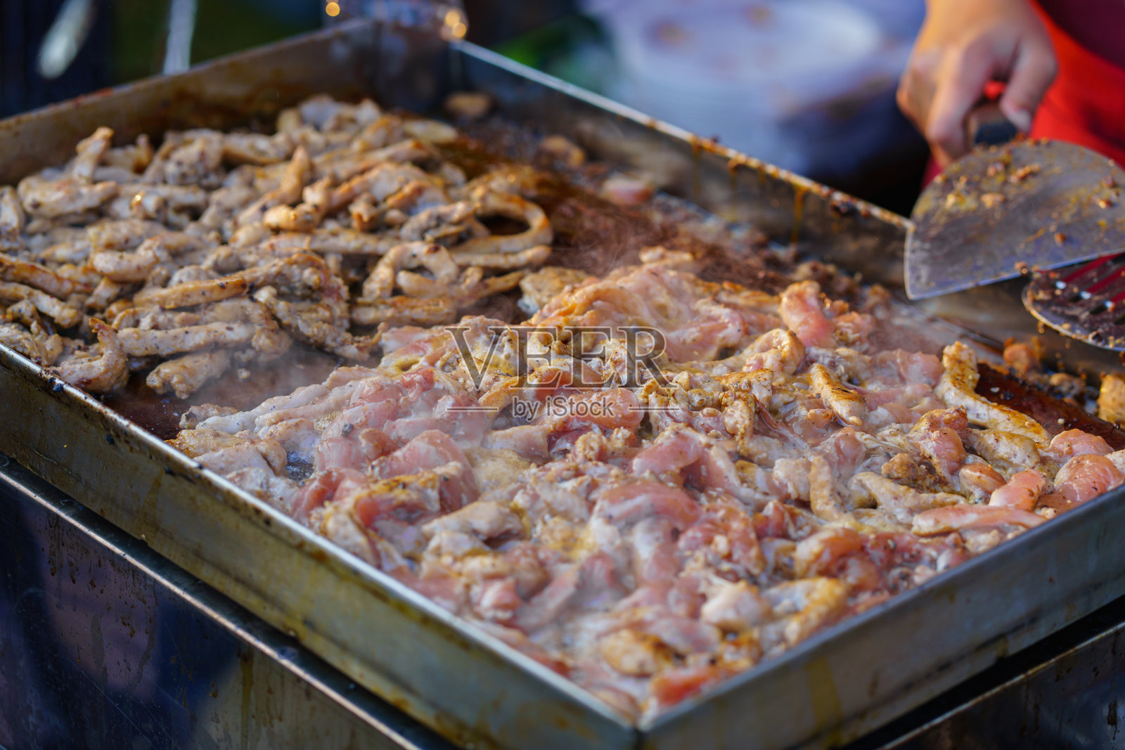 在街头小吃市场的煤气炉上用平底锅烹饪炸蒜排骨照片摄影图片