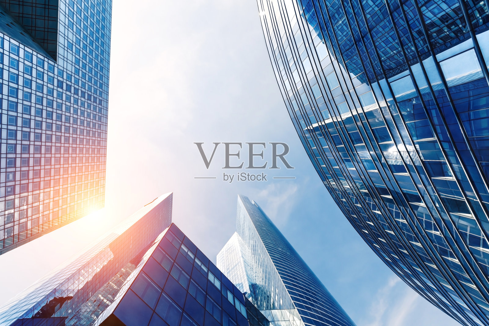 金融区的写字楼，阳光和天空反射在摩天大楼的现代玻璃墙。商业背景。低视角照片摄影图片