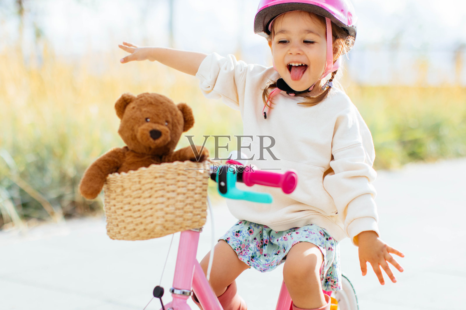 快乐开朗的小女孩在公园里骑自行车照片摄影图片