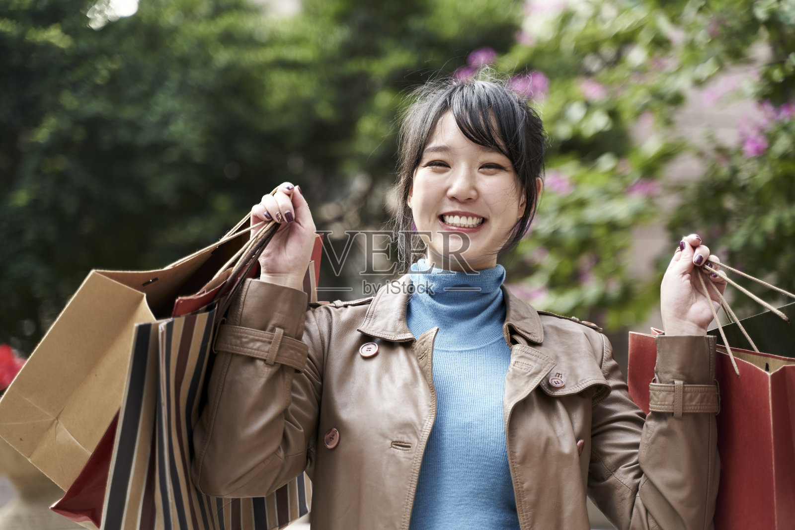快乐的年轻亚洲女人与购物袋照片摄影图片