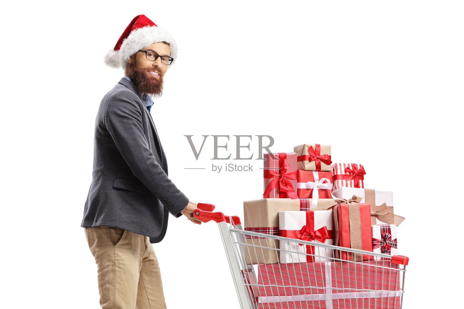 戴着圣诞帽的大胡子男人推着装满圣诞礼物的购物车照片摄影图片