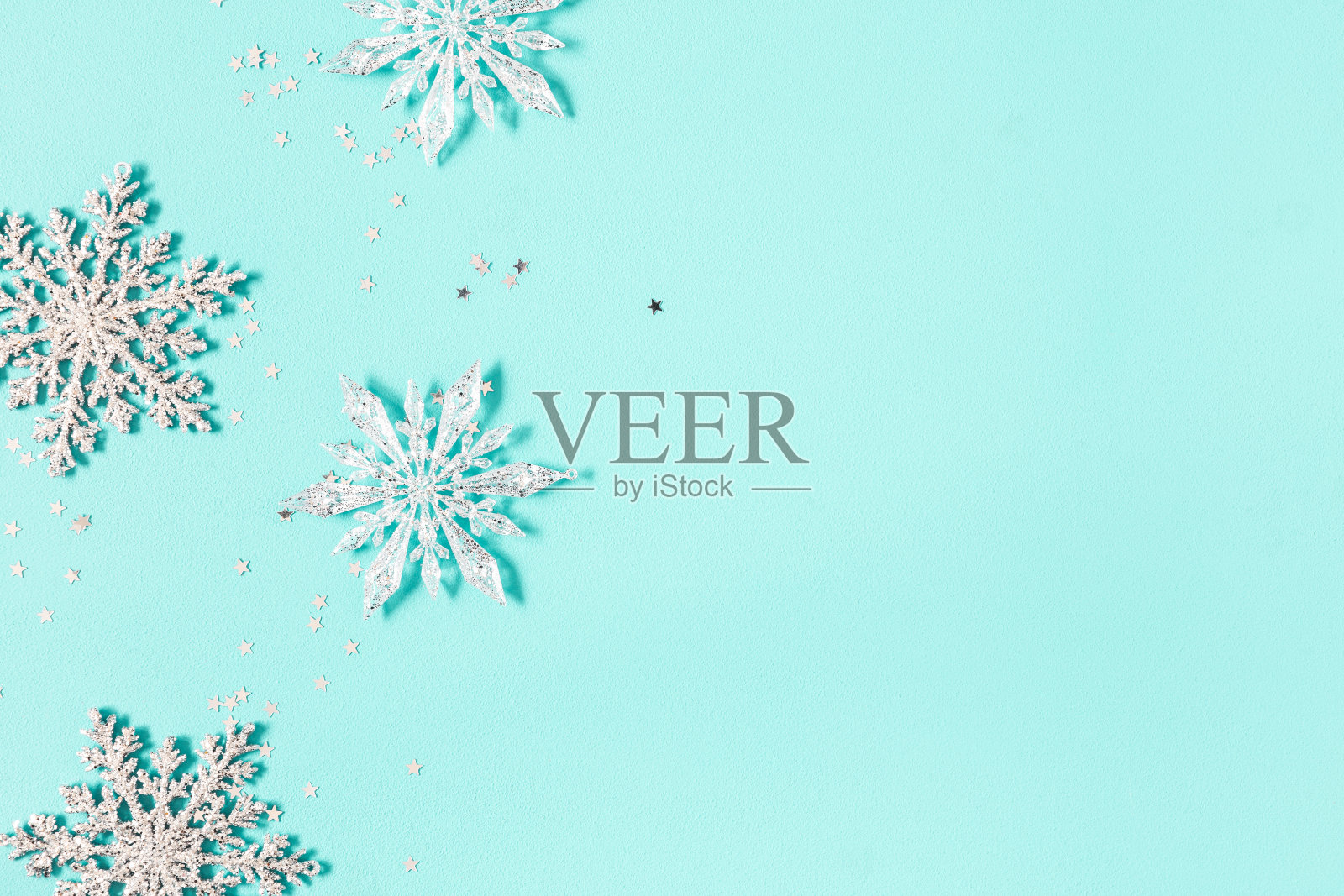 圣诞组成。淡蓝色背景上的银色雪花。圣诞节，冬天，新年的概念。平铺，俯视图，拷贝空间照片摄影图片
