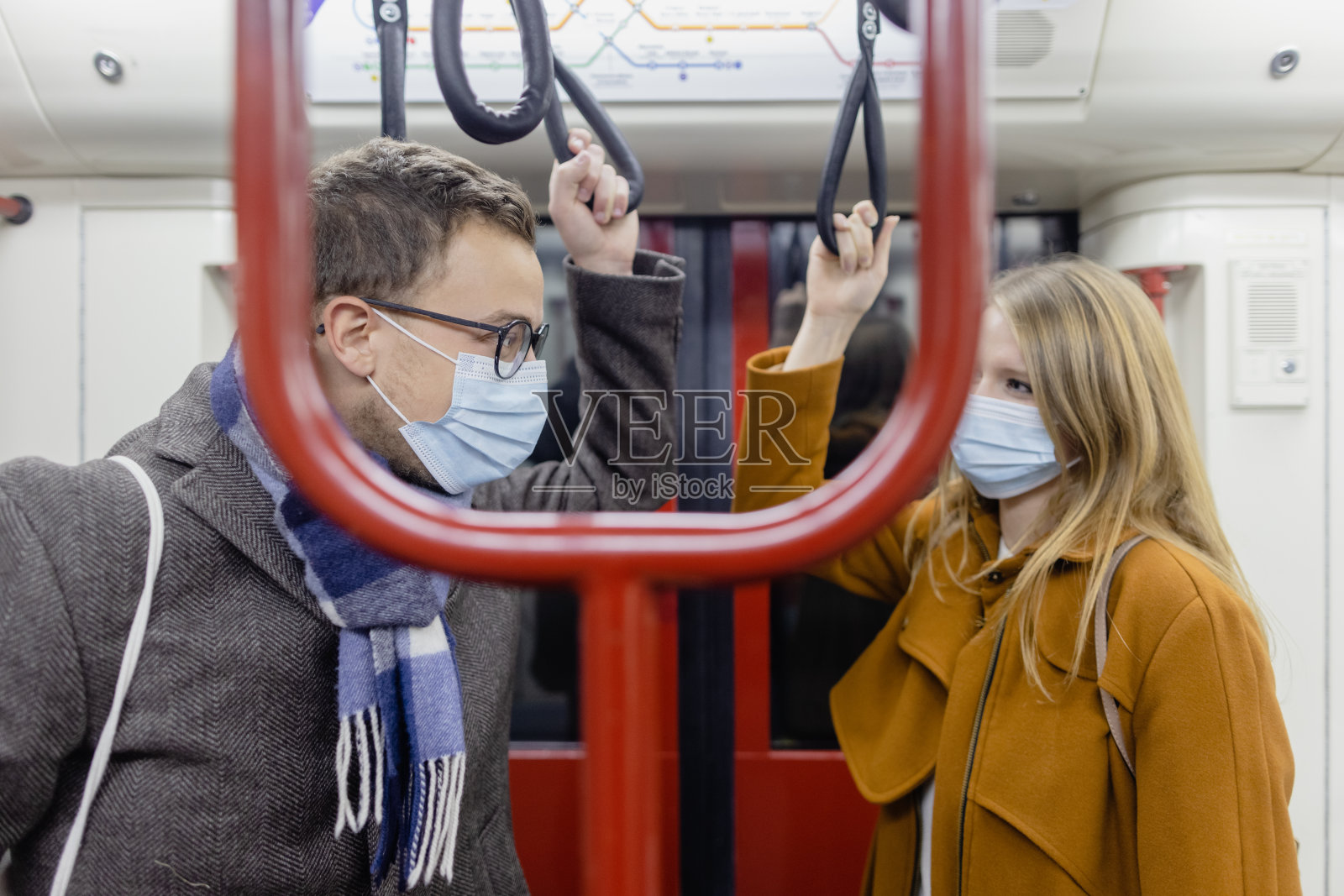 一对戴着冠状病毒口罩的调情情侣在火车上照片摄影图片