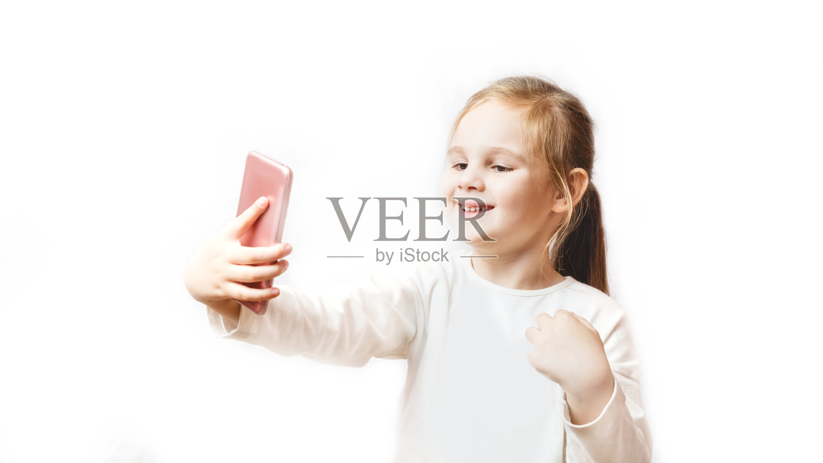 一个白人小女孩在用智能手机自拍。现代无线技术和设备概念。白色背景照片摄影图片