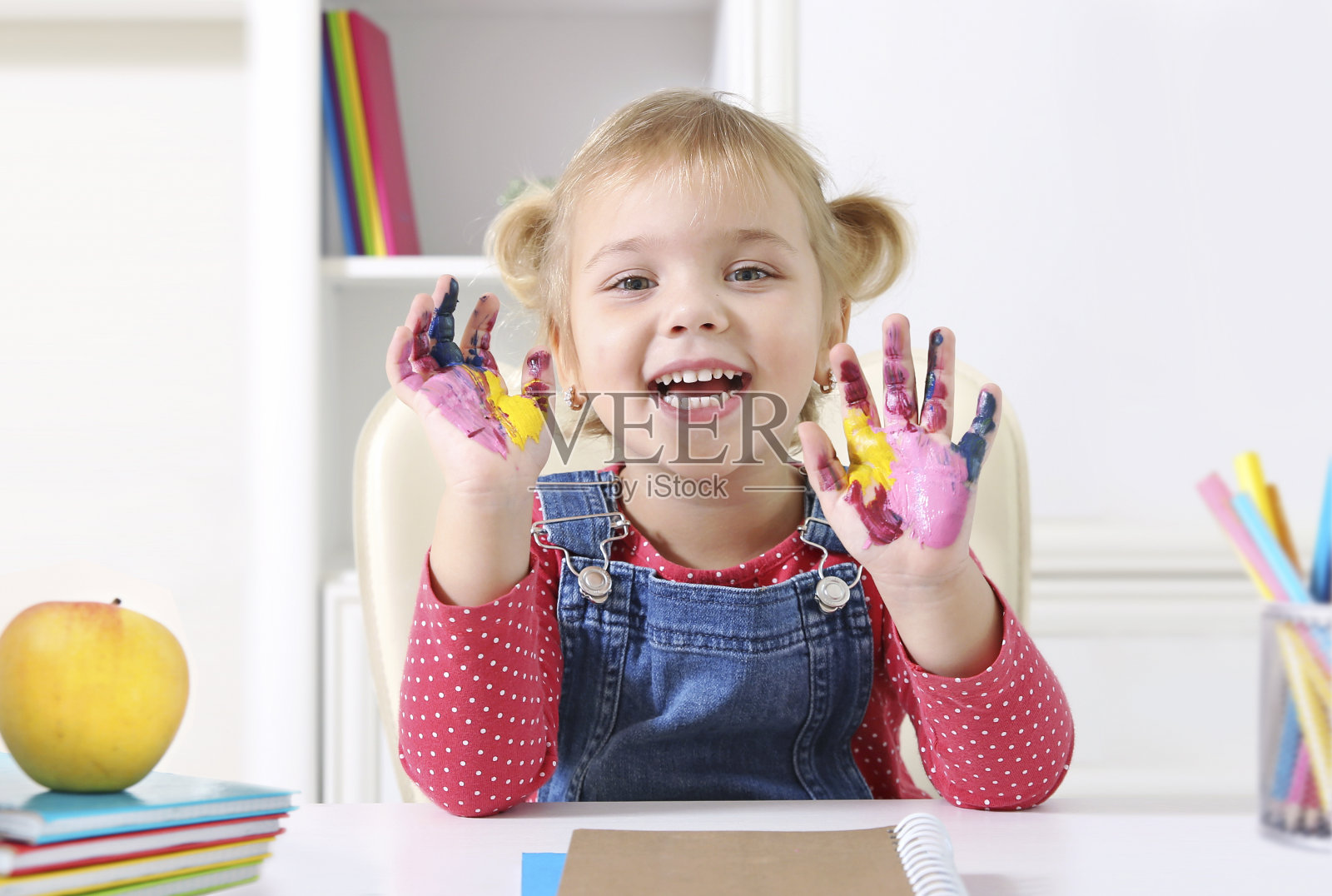 小女孩展示着彩绘的双手，快乐的小女孩学习美术。学画画。照片摄影图片