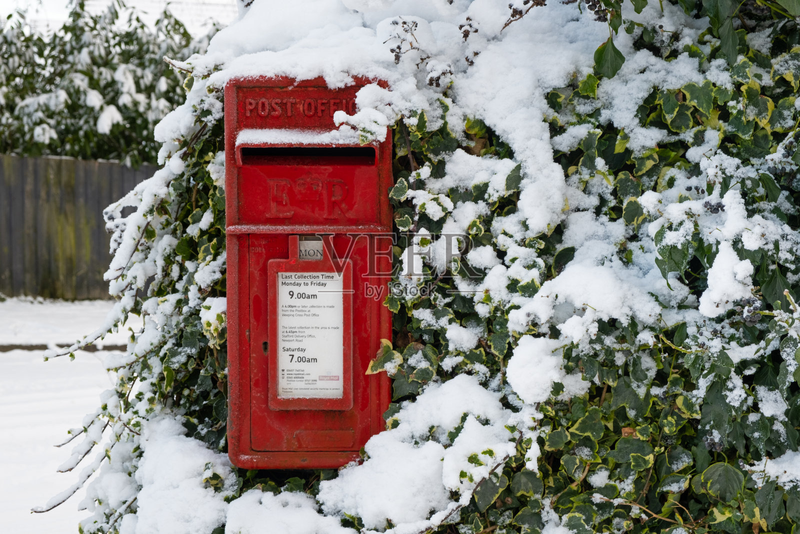 传统的英国红色信箱在冬天下雪照片摄影图片