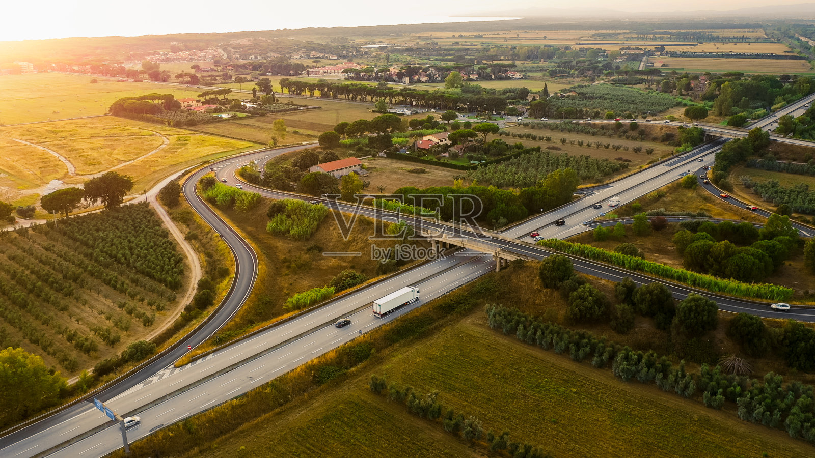 无人机拍摄:意大利的高速公路，周围环绕着农场，农业种植园，蔬菜种植地照片摄影图片