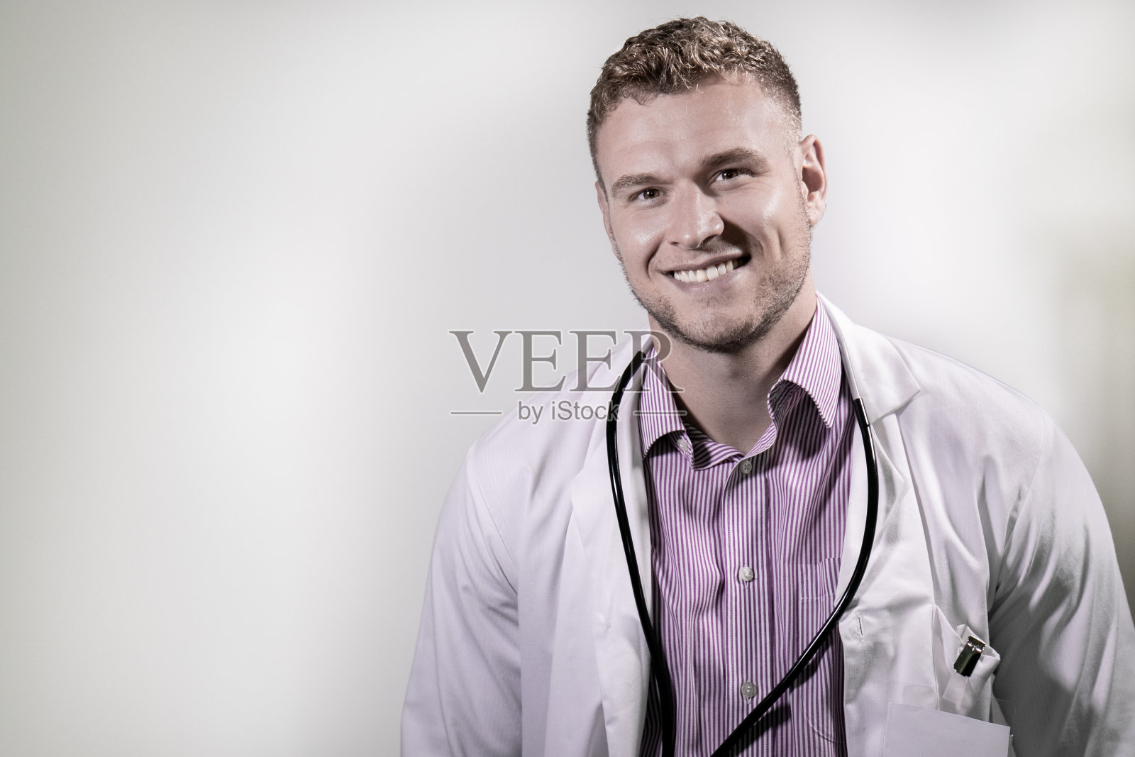 英俊的男医生在镜头前微笑的白色背景与副本的空间照片摄影图片