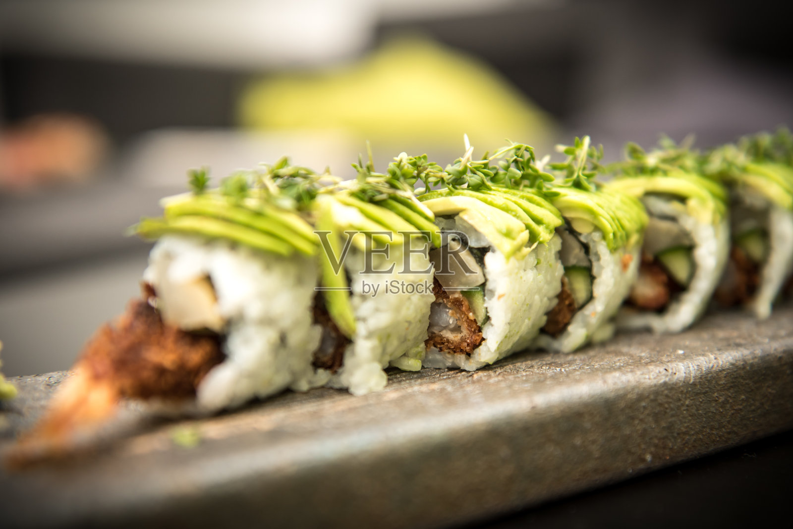 寿司卷和大虾放在石盘里照片摄影图片