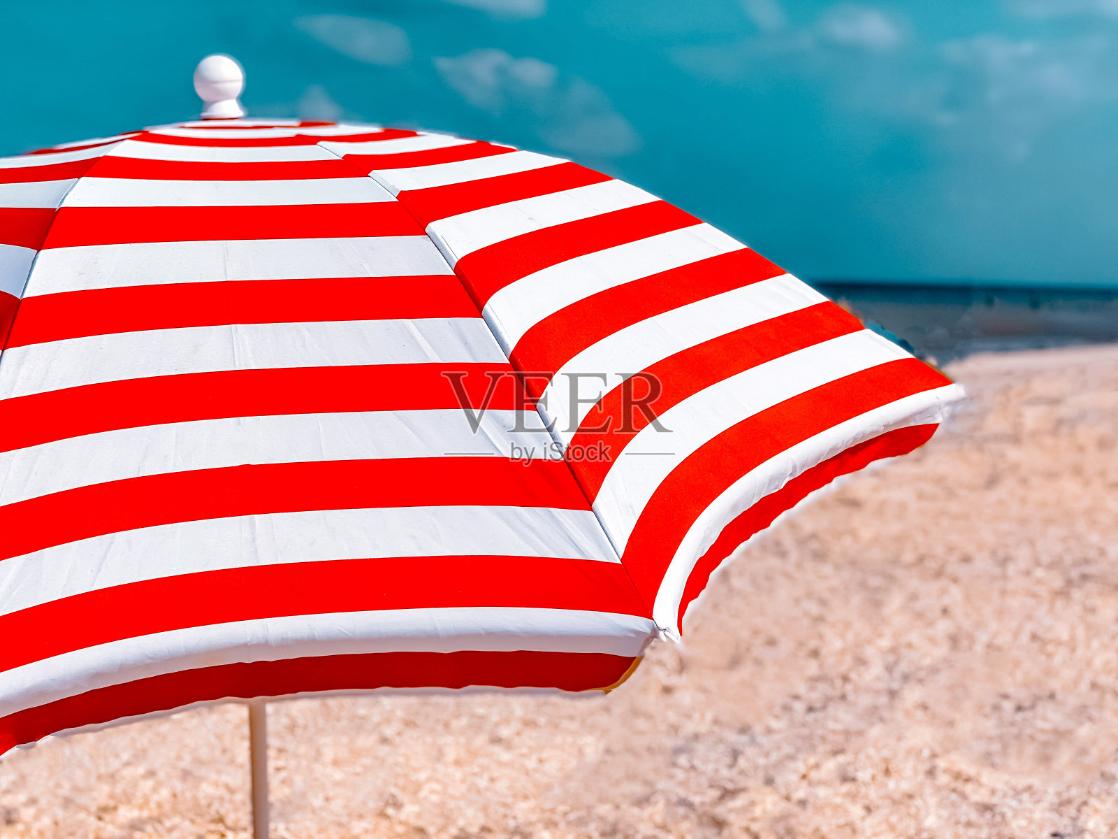 一部分的条纹沙滩伞映衬着美丽的蓝天，侧视图照片摄影图片