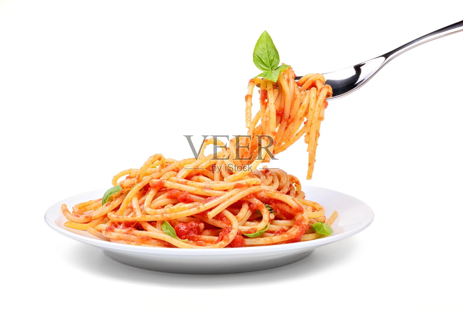 白色背景上用叉子分开的番茄和罗勒意大利面。照片摄影图片