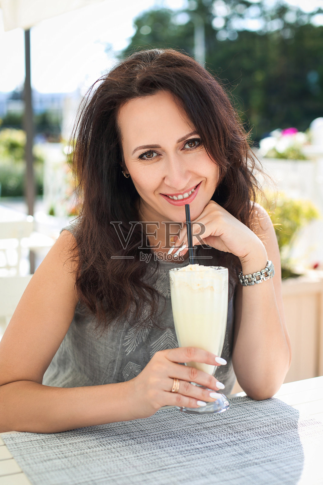 年轻漂亮的黑发女子在享受一杯拿铁咖啡照片摄影图片