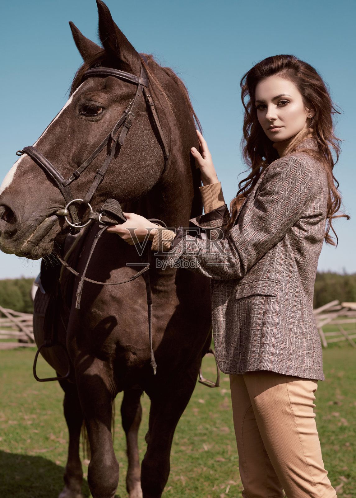 漂亮的黑发女人穿着优雅的格子夹克和一匹马照片摄影图片